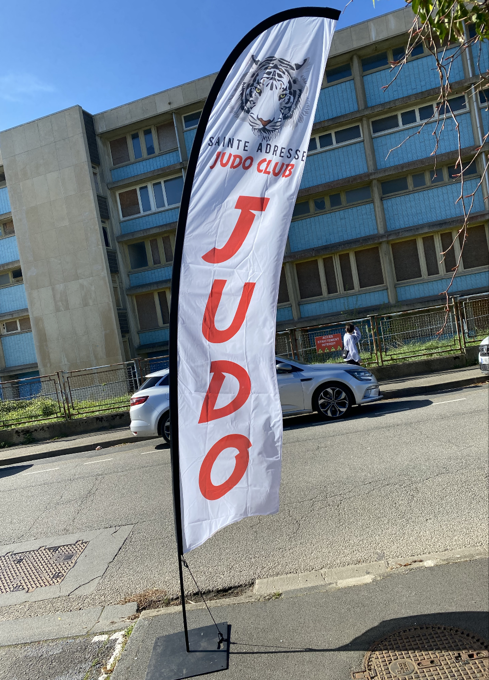 Drapeau judo avec le logo personnalisé pour le Club de Sainte Adresse en Normandie. Le drapeau a une voile blanche il mesure 3m et une écriture rouge