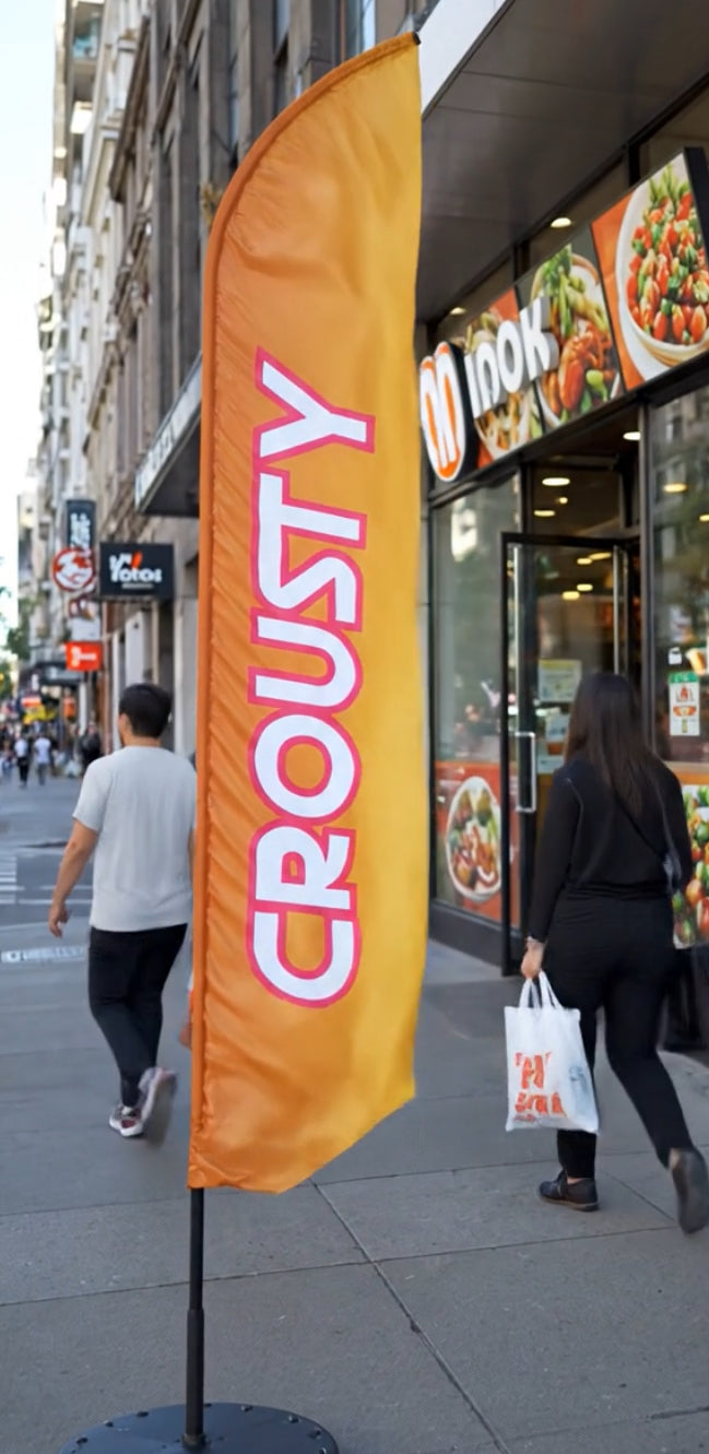 Vidéo du drapeau crousty de la boutique flag minute dans une rue passante composée d'une voile aux couleurs attirantes et un écriture large
