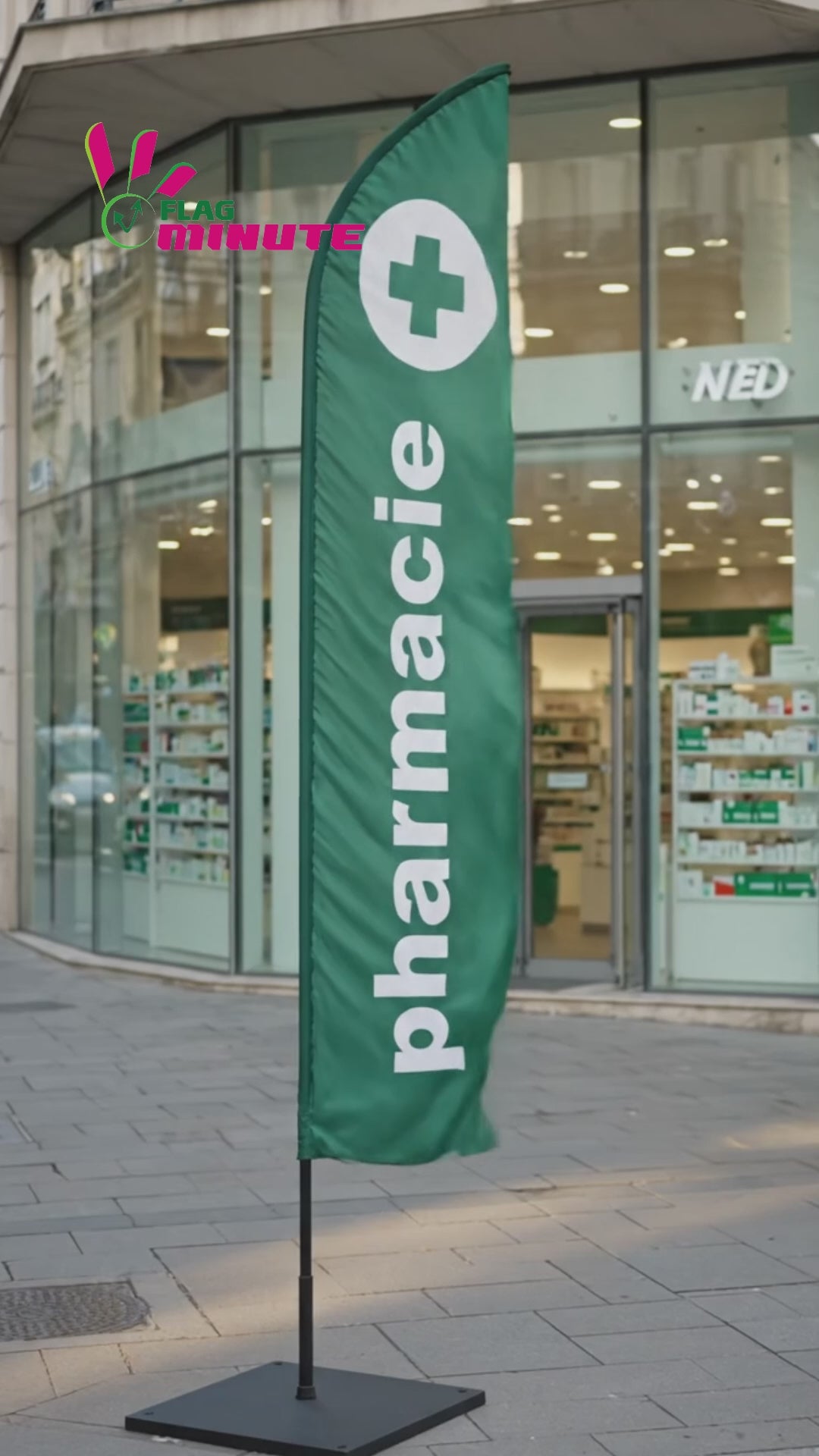 Spot vidéo du drapeau oriflamme publicitaire vert avec inscription 'PHARMACIE' en lettres blanches